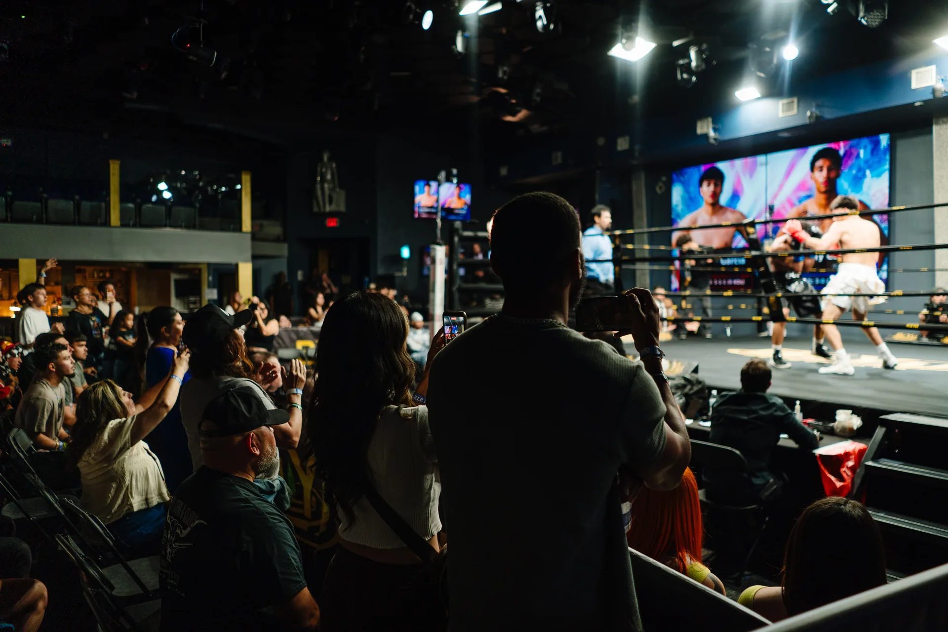 Wide view of the BIYU Arena floor, ring, and screen on a fight night